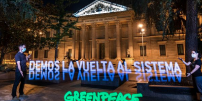 Greenpeace despliega una pancarta de luz frente al Congreso para pedir la transformación del sistema en clave verde