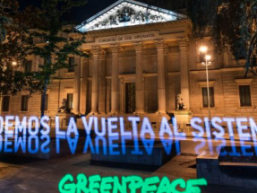 Greenpeace despliega una pancarta de luz frente al Congreso para pedir la transformación del sistema en clave verde